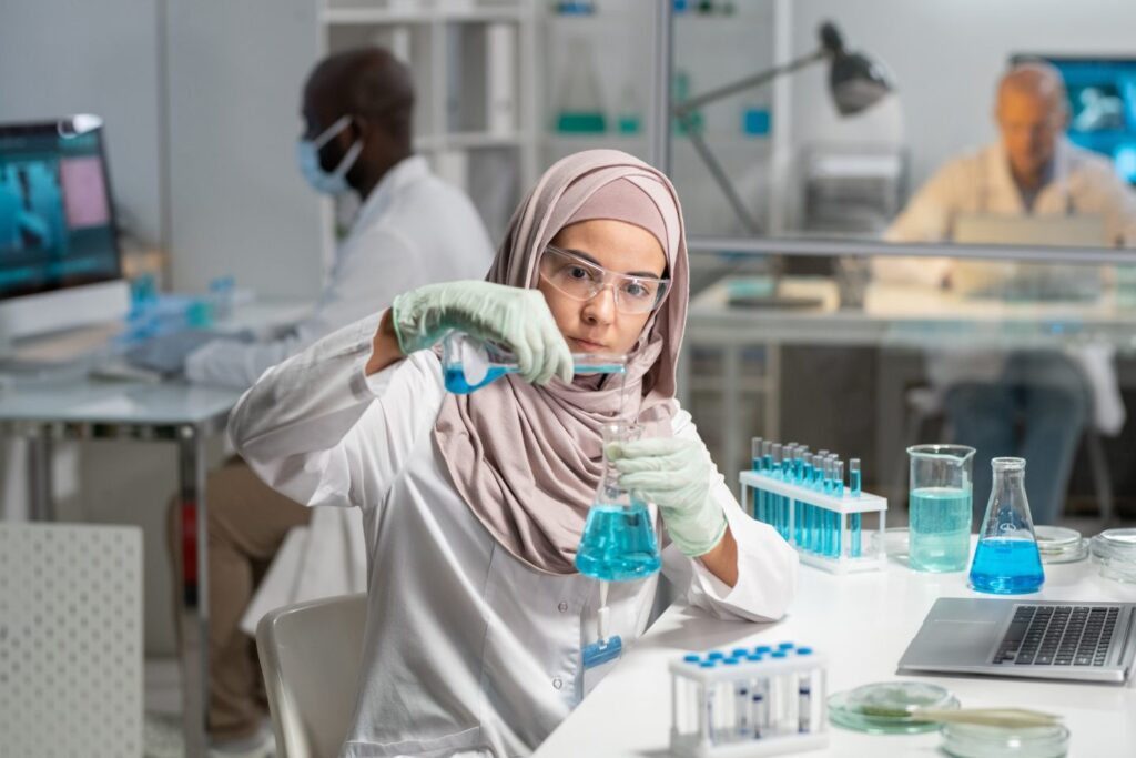 serious-female-researcher-pouring-liquid-substance-into-flask-with-blue-fluid